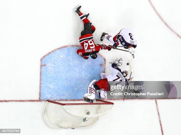 Sergei Bobrovsky of the Columbus Blue Jackets makes a save as Joseph Blandisi of the New Jersey Devils and Seth Jones of the Columbus Blue Jackets...