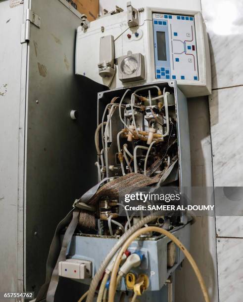 Picture taken on March 16, 2017 shows an out-of-service dialysis machine inside a basement-turned-clinic in the rebel-held town of Douma, on the...