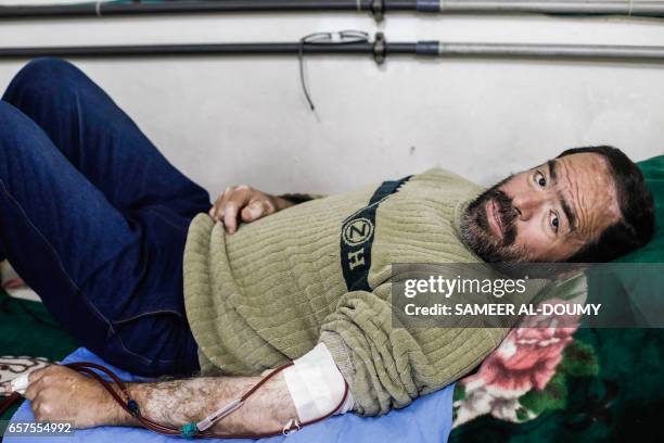 Abu Ammar, a 58-year-old Syrian who has suffered from renal insufficiency for 11 years, lies on a bed as he receives a dialysis session inside a...