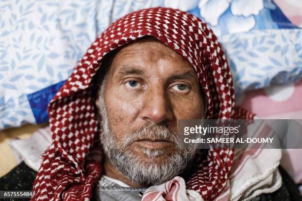 Abu Hosam, a 50-year-old Syrian who has suffered from renal insufficiency since three months prior, lies on a bed as he receives a dialysis session...