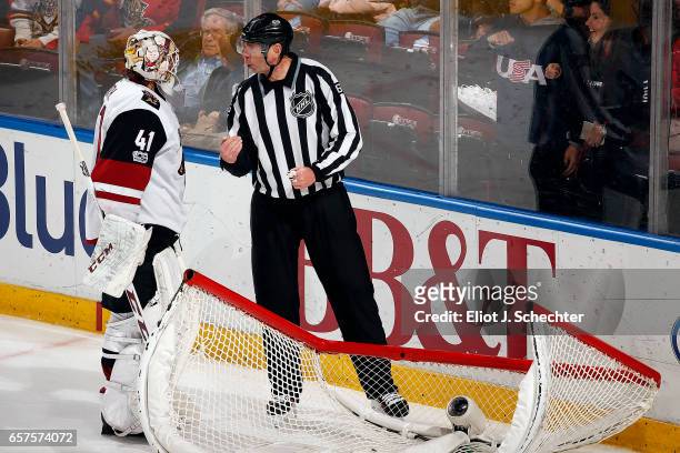 Goaltender Mike Smith of the Arizona Coyotes chats with NHL Linesmen Pierre Racicot after the net became dislodged against the Florida Panthers at...