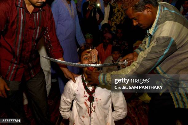 This photograph taken late March 24 shows an Indian Muslim having his tongue cut during 'Rafai Silsila' at The Shah-E-Alam Roja in Ahmedabad, during...