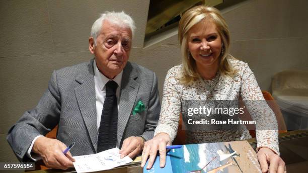 Portrait of Scottish photographer Harry Benson sits with writer Hilary Geary Ross as they attend at a book signing at the Bucceletti Jewelry Store,...