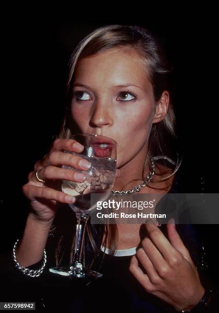 British fashion model Kate Moss drinks at a Council of Fashion Designers event held in the New York Public Library, New York, New York, 1993.