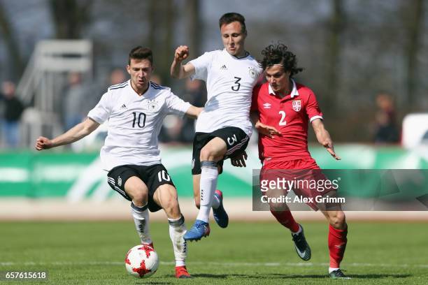 Sava Radic of Serbia is challenged by Dominik Franke and Salih Oezcan of Germany during the UEFA Elite Round match between U19 Germany and U19 Serbia...