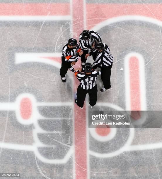 Officials Jean Hebert, Kyle Rehman, Darren Gibbs and Tim Kowak gather at center ice prior to the start of a NHL game between the Philadelphia Flyers...