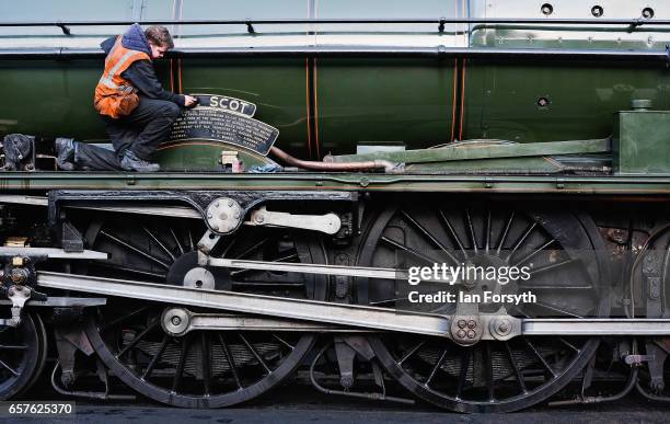 Volunteer cleans the brasses on the steam locomotive Royal Scot as it is prepared in Grosmont engine sheds ahead of running between Grosmont and...