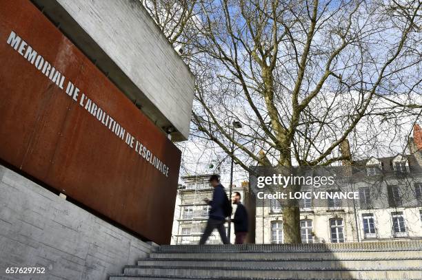 People pass the Abolition of Slavery Memorial Museum on March 24, 2017 in Nantes, western France. Five years ago, Nantes inaugurated its Memorial of...