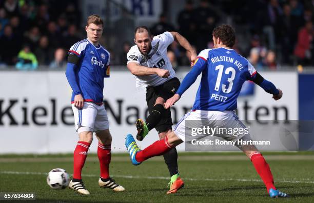 Christopher Handke of Magdeburg competes with Alexander Bieler and Dominic Peitz of Kiel during the Third League match between Holstein Kiel and 1....