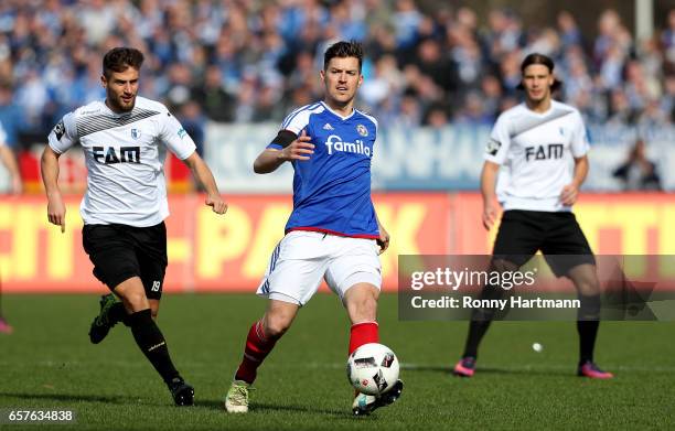 Tim Siedschlag of Kiel vies with Michel Niemeyer and Tobias Schwede of Magdeburg during the Third League match between Holstein Kiel and 1. FC...