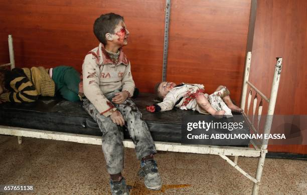 Wounded Syrian children cry as they wait to receive treatment following a reported air strike on the rebel-controlled town of Hammuriyeh, in the...