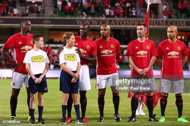 Louis Saha, Dwight Yorke, Quinton Fortune, Keith Gillespie and Danny Webber of the Manchester United Legends line up for the national anthems during...