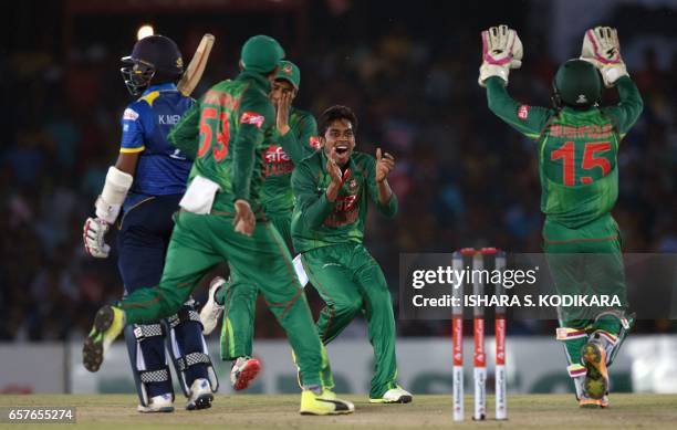 Bangladesh cricketer Mehedi Hasan celebrates with teammates after he dismissed Sri Lankan cricketer Kusal Mendis during the first one day...