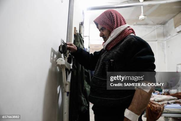 Syrian Abu Yaseen checks his weight after undergoing haemodialysis treatment in the basement-turned-clinic in the rebel-held town of Douma, on the...