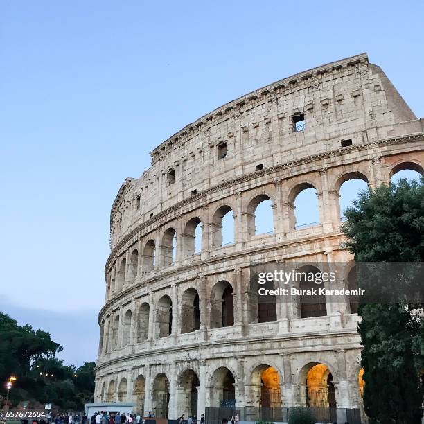 a large section of the colosseum among blue sky - romeinse rijk stockfoto's en -beelden
