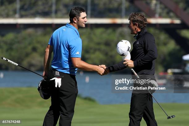 Jon Rahm of Spain shakes hands with Charles Howell III after winning their match 6&4 on the 14th hole during round four of the World Golf...