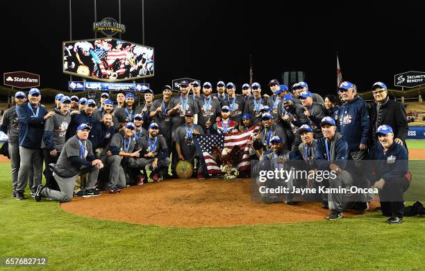 Members of the United States team pose for a photo on the pitcher's mound after defeating Puerto Rico in the 2017 World Baseball Classic at Dodger...