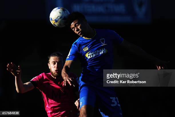 Lyle Taylor of A.F.C. Wimbledon and Ben Coker of Southend United challenge for the ball during the Sky Bet League One match between A.F.C. Wimbledon...