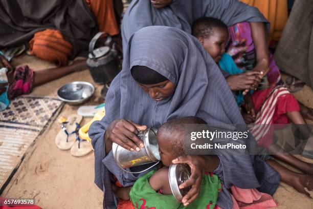 Mother feeding her baby. Somalia in the grip of an unprecedent and devastating food crisis. Drought has caused crops to fail and cattle to die in...