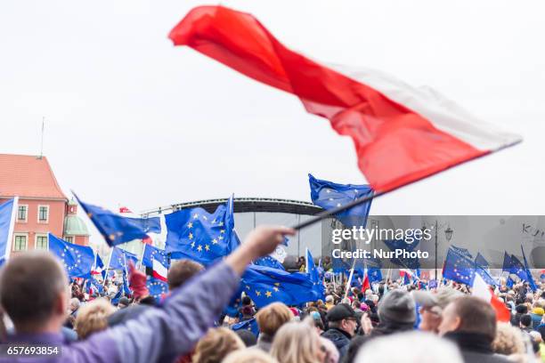 People wave EU and Polish flags during a demonstration 'I Love You Europe' to mark the 60th anniversary of the Rome treaty in Warsaw, Poland on 25...