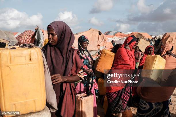 Women filling jerrycans with water from dwell implemented by Polish Humanitarian Action.Somalia in the grip of an unprecedent and devastating food...