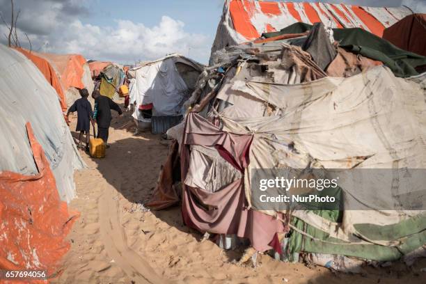 Boys carrying jerrycan with water. Somalia in the grip of an unprecedent and devastating food crisis. Drought has caused crops to fail and cattle to...