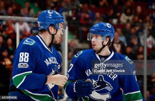 Nikita Tryamkin of the Vancouver Canucks talks to teammate Ben Hutton during their NHL game against the New York Islanders at Rogers Arena March 9,...