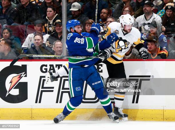 Joseph Cramarossa of the Vancouver Canucks checks Brian Dumoulin of the Pittsburgh Penguins during their NHL game at Rogers Arena March 11, 2017 in...