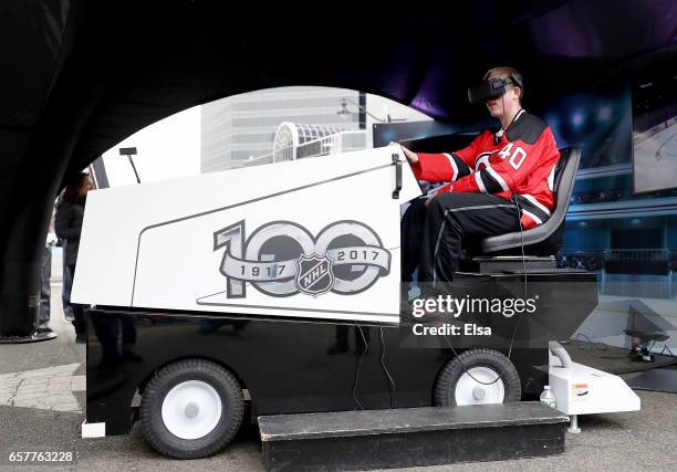 Fan takes part in the virtual Zamboni ride as part of the NHL Centennial Truck tour open to fans before the game between the New Jersey Devils and...