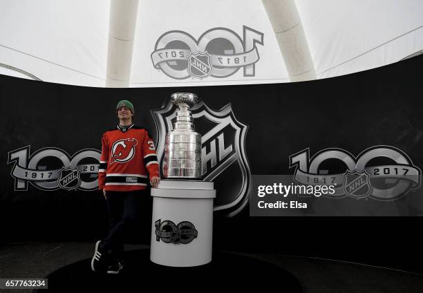 Fans pose with the Stanley Cup as part of the NHL Centennial Truck tour open to fans before the game between the New Jersey Devils and the Carolina...