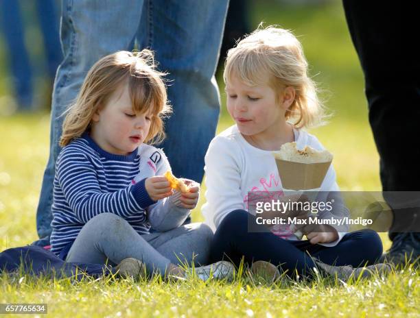 Mia Tindall and cousin Isla Phillips eat crepes as they attend the Gatcombe Horse Trials at Gatcombe Park on March 25, 2017 in Stroud, England.