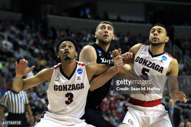 Sean O'Mara of the Xavier Musketeers is boxed out by Johnathan Williams and Nigel Williams-Goss of the Gonzaga Bulldogs during the 2017 NCAA Men's...