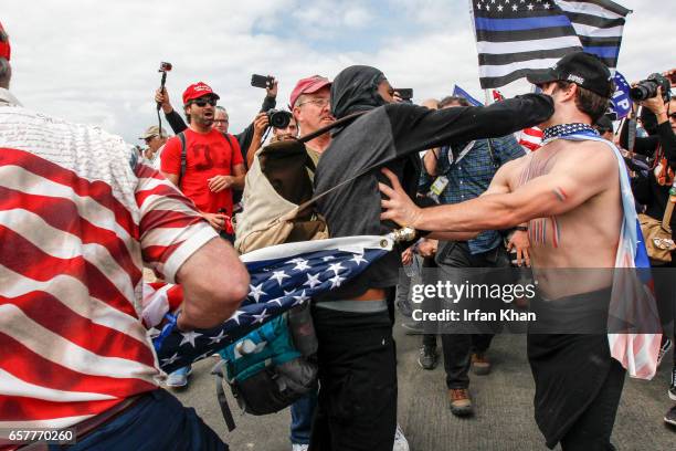 Scuffle breaks out between Pro-Trump and Anti-Trump protestors during Make America Great Again March on March 25, 2017 in Huntington Beach. According...