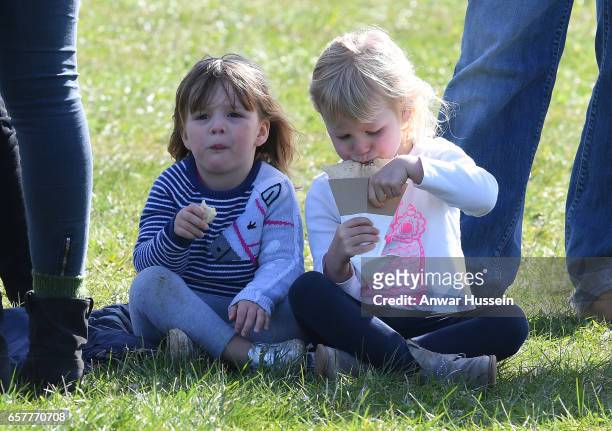 Mia Tindall enjoys a snack with her cousin Isla Phillips during the Gatcombe Horse Trials at Gatcombe Park on March 25, 2017 in Stroud, England.