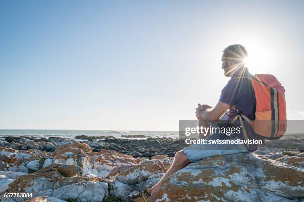 jonge man op strand overweegt weergave, ontspanning - headland stockfoto's en -beelden