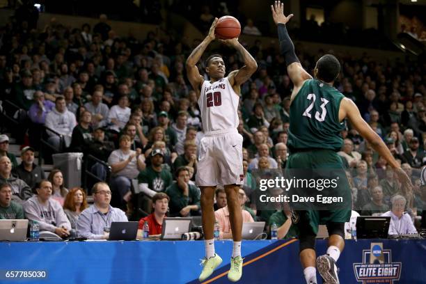 Shammgod Wells of Fairmont State University shoots overChris-Ebou Ndow of Northwest Missouri State University during the Division II Men's Basketball...