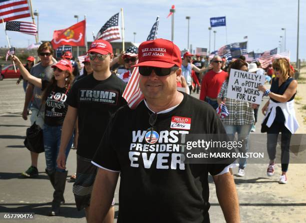 Supporters of US President Trump march during the "Make America Great Again" rally in Huntington Beach, California on March 25, 2017. / AFP PHOTO /...