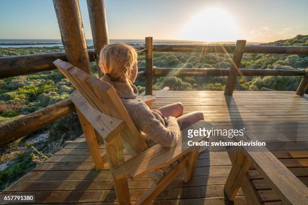 jeune femme détente sur la terrasse au coucher du soleil - southern africa photos et images de collection
