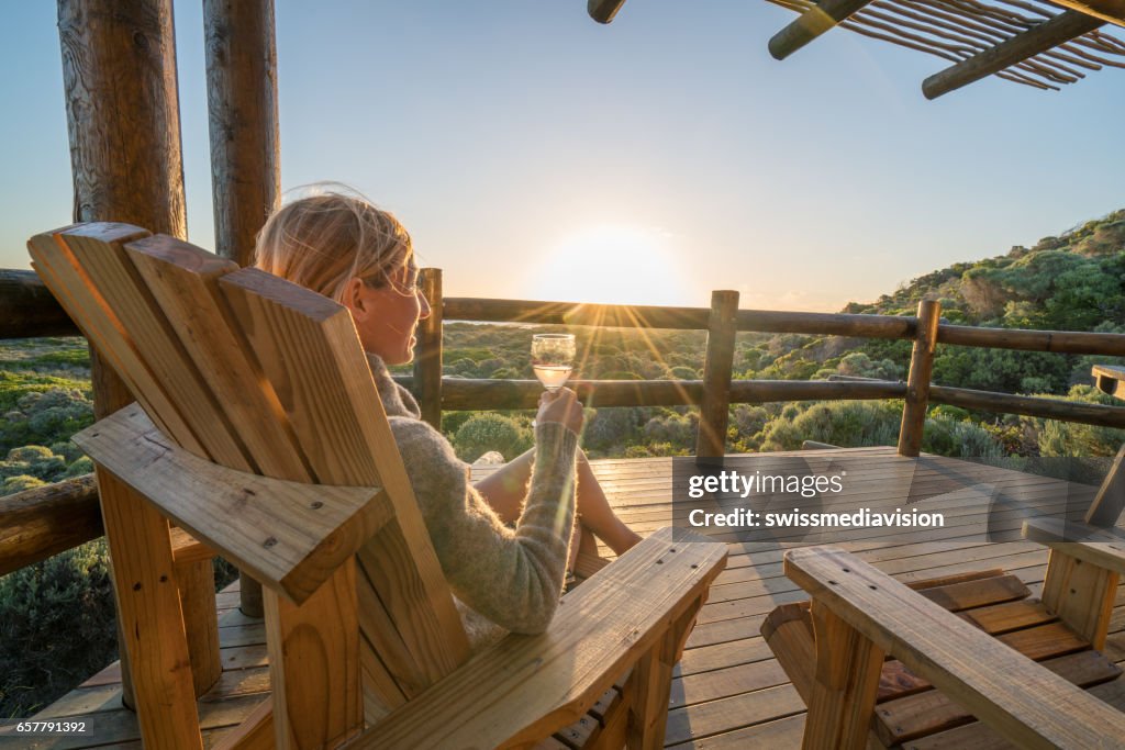 Junge Frau entspannen auf der Terrasse bei Sonnenuntergang