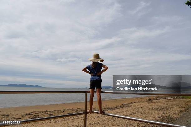 Young girl stands on railings looking out to sea as residents prepare and wait for Cyclone Debbie on March 26, 2017 in Townsville, Australia. Cyclone...