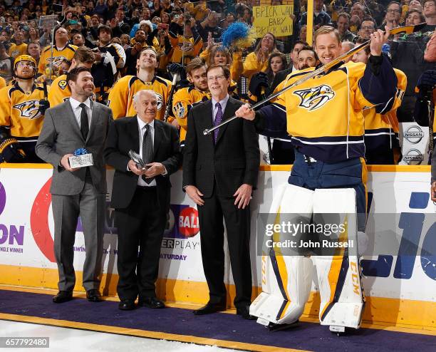 Pekka Rinne of the Nashville Predators receives his silver stick from GM David Poile for his 500th career NHL game prior to a game against the San...