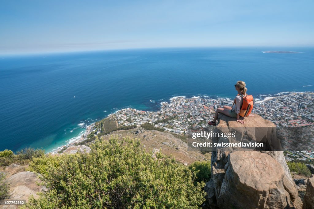 Young woman in Cape Town on top of mountain looking at view
