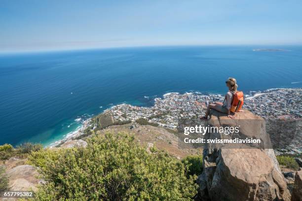 jovem mulher em cape town no topo da montanha, olhando a vista - cidade do cabo - fotografias e filmes do acervo