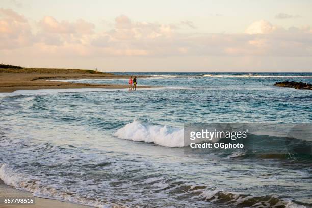interratial paar lopen op een prachtig strand - ogphoto stockfoto's en -beelden