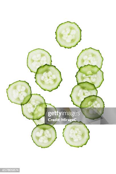 cucumber slices on white background - komkommer stockfoto's en -beelden