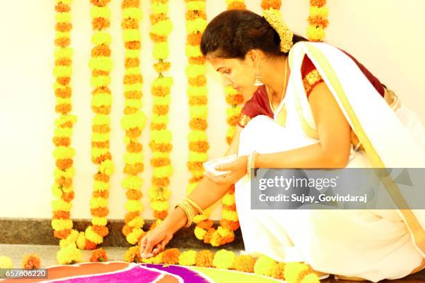 donna indiana che decora il pavimento - onam foto e immagini stock