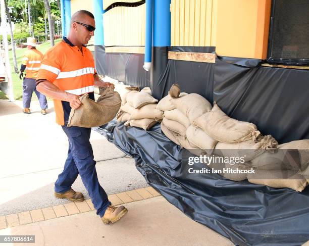 Council worker helps sandbag a Surf Lifesaving building along the Strand in preparation for Cyclone Debbie on March 26, 2017 in Townsville,...