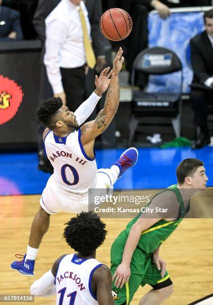 Kansas guard Frank Mason III makes a 3-point attempt while off his feet against Oregon's Payton Pritchard in the first half during the NCAA...