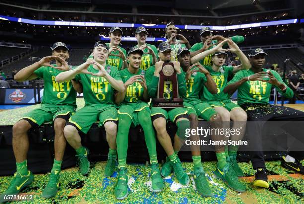 The Oregon Ducks pose after defeating the Kansas Jayhawks 74-60 during the 2017 NCAA Men's Basketball Tournament Midwest Regional at Sprint Center on...