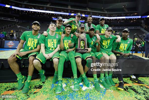 The Oregon Ducks pose after defeating the Kansas Jayhawks 74-60 during the 2017 NCAA Men's Basketball Tournament Midwest Regional at Sprint Center on...